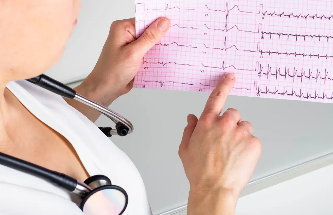 A clinician reviewing an ECG printout